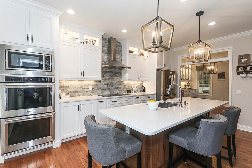 Updated kitchen with white cabinets, eat in kitchen island, double oven. Medium brown hardwood floors and stainless steel appliances